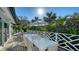 Outdoor dining area with a large white dining table surrounded by lush tropical greenery at 1302 Roberts Bay Ln, Sarasota, FL 34242