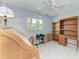 Sunlit bedroom with wood furnishings, tiled floors, a ceiling fan, and weights at 1346 Queen Rd, Venice, FL 34293