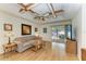 Comfortable living room with ceiling fan, wood flooring, and sliding doors to lanai at 1346 Queen Rd, Venice, FL 34293