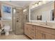 Bathroom featuring a glass shower, double sink vanity, and a neutral color palette at 1359 Tearose Pl, Sarasota, FL 34239