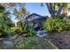 Exterior view of the home with screened lanai and lush backyard, perfect for outdoor living at 1359 Tearose Pl, Sarasota, FL 34239