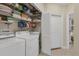 Laundry room with washer, dryer, shelving, and a neutral color palette at 1359 Tearose Pl, Sarasota, FL 34239