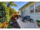 Outdoor patio area with a table and chairs, surrounded by lush landscaping at 1359 Tearose Pl, Sarasota, FL 34239