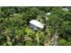 Aerial view showing home, pool, and large lot with mature trees at 14018 Pine Woods E Ln, Sarasota, FL 34240