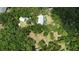 Aerial view of home with pool and detached garage nestled in a wooded area at 14018 Pine Woods E Ln, Sarasota, FL 34240