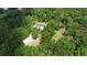 Aerial view of property showcasing home, detached garage, and expansive wooded lot at 14018 Pine Woods E Ln, Sarasota, FL 34240