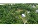 Aerial view of home on wooded lot with a screened pool at 14018 Pine Woods E Ln, Sarasota, FL 34240