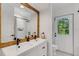 Bathroom with double vanity, white subway tile, and a wood framed mirror at 14018 Pine Woods E Ln, Sarasota, FL 34240