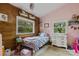 Charming bedroom with wood-paneled accent wall and a comfortable bed at 14018 Pine Woods E Ln, Sarasota, FL 34240