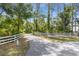 White fence lines a paved driveway leading to a home at 14018 Pine Woods E Ln, Sarasota, FL 34240