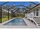 Screened-in pool with surrounding deck and backyard view at 14018 Pine Woods E Ln, Sarasota, FL 34240