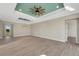 Bright dining room with tray ceiling, wood-look floors, and access to the kitchen at 144 Spring Dr, Rotonda West, FL 33947