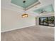 Spacious living area with light walls, wood-look floors, and a tray ceiling at 144 Spring Dr, Rotonda West, FL 33947