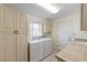 Bright laundry room with washer, dryer, and ample cabinet space at 1441 Gleneagles Dr, Venice, FL 34292