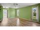 Bedroom with light green walls, wood-look floors, and ample natural light at 157 Da Vinci Dr, Nokomis, FL 34275