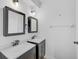 Bathroom boasting dual sinks with dark cabinetry, mirrors and modern fixtures at 1671 Mellon Way, Sarasota, FL 34232