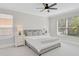 Comfortable bedroom with neutral tones, two windows, ceiling fan, and soft carpet at 1671 Mellon Way, Sarasota, FL 34232