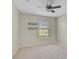 Minimalist bedroom with a ceiling fan, a large window, and carpeted floors at 1671 Mellon Way, Sarasota, FL 34232