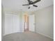 Bright bedroom features a ceiling fan, carpeted floor, and a closet with white paneled doors at 1671 Mellon Way, Sarasota, FL 34232