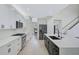 Contemporary kitchen with white cabinets, a dark island, and stainless steel appliances at 1671 Mellon Way, Sarasota, FL 34232