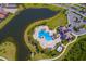 Aerial view of community pool, lake, and amenity center with lush tropical landscaping at 16730 Collingtree Xing, Lakewood Ranch, FL 34202