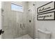 Modern bathroom featuring a glass-enclosed shower with marble tile and decorative wall art at 16730 Collingtree Xing, Lakewood Ranch, FL 34202