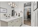 Modern bathroom with double sinks, quartz countertops, soft lighting, and walk-in closet access at 16730 Collingtree Xing, Lakewood Ranch, FL 34202