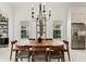 Bright dining room featuring a wood table, modern chandelier, and views through plantation shutters at 16730 Collingtree Xing, Lakewood Ranch, FL 34202