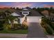 Gorgeous home exterior featuring a manicured lawn, brick driveway and three-car garage at 16730 Collingtree Xing, Lakewood Ranch, FL 34202