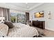 The main bedroom features hardwood floors, a mounted TV, and a picturesque window view with plantation shutters at 16730 Collingtree Xing, Lakewood Ranch, FL 34202