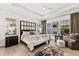 Bright main bedroom featuring hardwood floors, tray ceilings, stylish furniture, and plantation shutters at 16730 Collingtree Xing, Lakewood Ranch, FL 34202