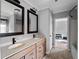 Bathroom featuring double vanity with wooden cabinets, large mirrors, and modern fixtures at 17555 Lake Worth Blvd, Port Charlotte, FL 33948