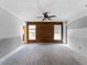 Unfinished bedroom featuring gray walls, wood accent wall, and ceiling fan at 17555 Lake Worth Blvd, Port Charlotte, FL 33948