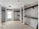 Unfinished walk-in closet featuring built in shelving, wood floors, and window at 17555 Lake Worth Blvd, Port Charlotte, FL 33948