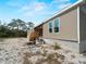 Exterior side view of home with porch, large windows, and foundation amidst natural surroundings at 17555 Lake Worth Blvd, Port Charlotte, FL 33948