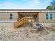 Home exterior with covered porch, wooden stairs, block foundation, and construction debris at 17555 Lake Worth Blvd, Port Charlotte, FL 33948