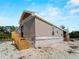 New construction home exterior featuring beige siding, block foundation and wooden stairs at 17555 Lake Worth Blvd, Port Charlotte, FL 33948