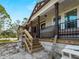 Inviting front porch with wooden steps and railing leading to a charming exterior at 17555 Lake Worth Blvd, Port Charlotte, FL 33948