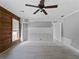 Spacious living room featuring wood accent wall, a ceiling fan, and ample natural light at 17555 Lake Worth Blvd, Port Charlotte, FL 33948