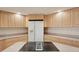 Close-up of kitchen featuring light wood cabinets, cooktop island, and white refrigerator at 20313 Navajo Ln, Port Charlotte, FL 33952