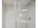 Updated shower features white tile, glass enclosure, and modern fixtures at 20313 Navajo Ln, Port Charlotte, FL 33952