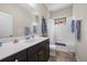 Clean bathroom with dark vanity, white countertop, and bathtub at 220 Alfero Way, Nokomis, FL 34275