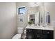 Small bathroom with dark vanity, white countertop, and toilet at 220 Alfero Way, Nokomis, FL 34275