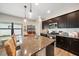 Island kitchen with granite countertops and dark brown cabinets at 220 Alfero Way, Nokomis, FL 34275