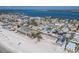 Aerial view of colorful beach homes along the shoreline, with a bridge visible in the distance and white sand beach at 2310 Gulf N Dr # 201, Bradenton Beach, FL 34217