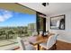 Modern dining room with a wood table, six chairs, contemporary lighting, and sliding doors to the balcony at 300 S Pineapple Ave # 802, Sarasota, FL 34236