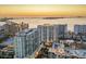 Stunning aerial view of luxury high-rise condos overlooking the ocean at sunset, showcasing prime waterfront real estate at 301 Quay Commons # 1411, Sarasota, FL 34236