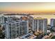 Beautiful aerial view of upscale condos with balconies at sunset, revealing waterfront cityscape and stunning water views at 301 Quay Commons # 1411, Sarasota, FL 34236