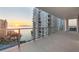 Expansive balcony with glass railings offers panoramic ocean views at sunset from this modern waterfront condo at 301 Quay Commons # 1411, Sarasota, FL 34236