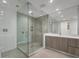 Modern bathroom featuring glass enclosed shower, vanity, and large mirror at 301 Quay Commons # 1411, Sarasota, FL 34236